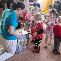 tety pomáhají dětem rozbalit a zprovoznit vánoční dárky
